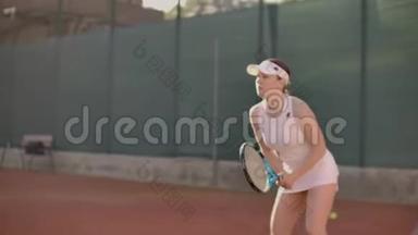 女子网球运动员在<strong>网球场</strong>上用球拍和日落时慢动作打网球